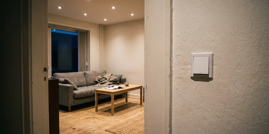 Vardagsrum med dimrade spotar och en vanlig strömbrytare